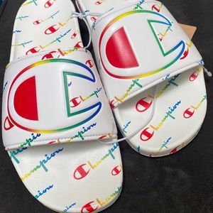 Champion white sandals with rainbow words all around.
